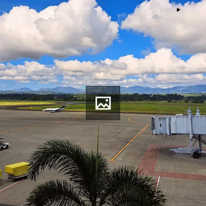 Airport runway with gate and vehicles