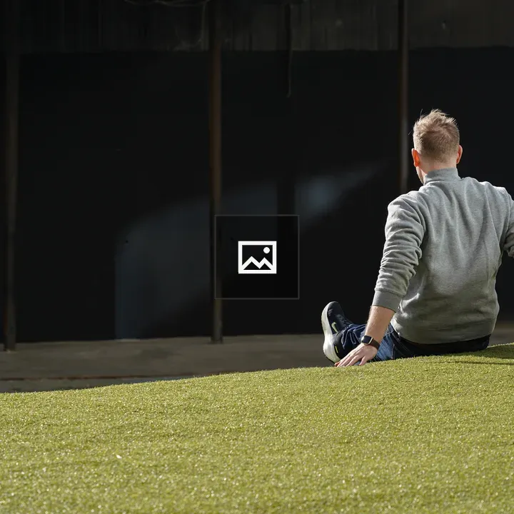 Person Sitting on Grassy Slope