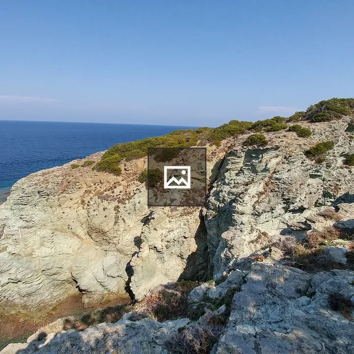 Rocky cliff by blue sea