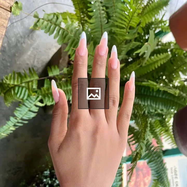 Hand with nails over ferns