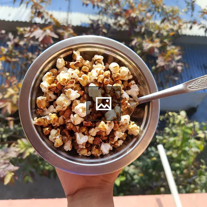 Hand holding bowl of popcorn