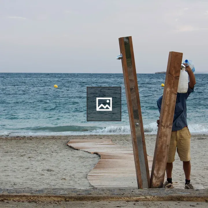 Man Refills Plastic Jugs at Beach Shower