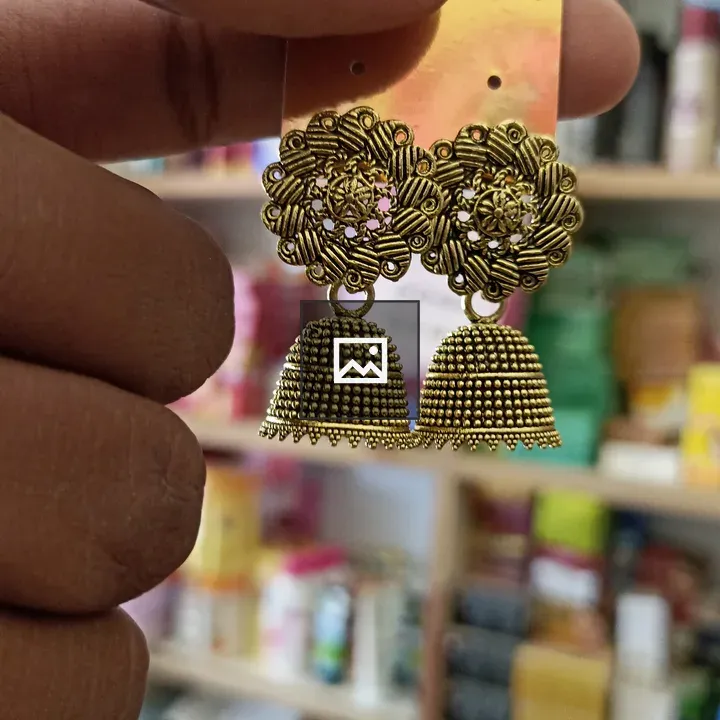 Hand holding floral metal earrings