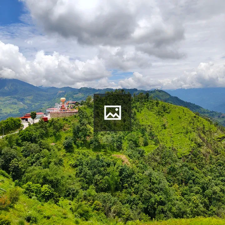 Temple atop lush hillside panorama