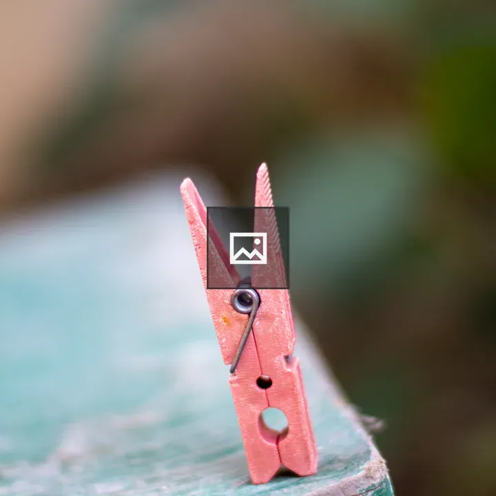 Pink clothespin on weathered surface