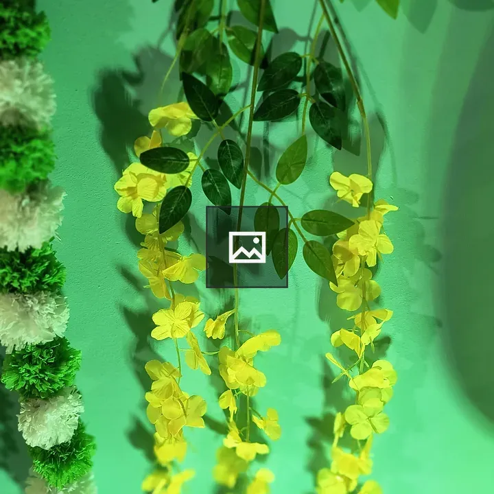 Artificial yellow flowers on green wall