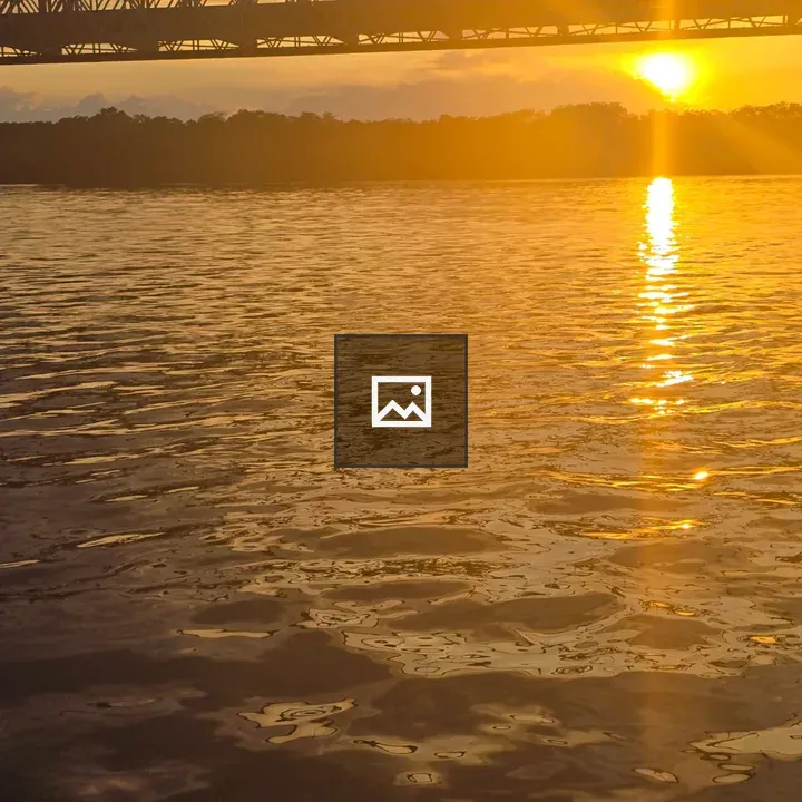 Sunset over water with bridge silhouette