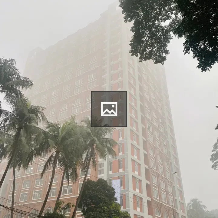 Tall red and white building in fog