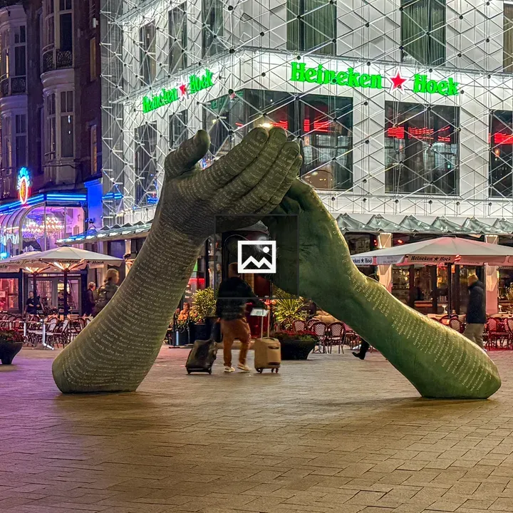 Oversized hands sculpture at night