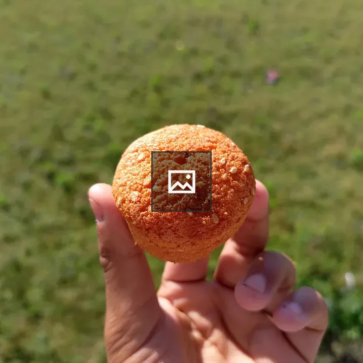 Hand holding orange baked snack