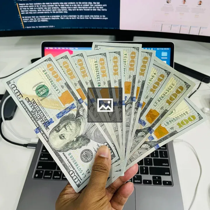 Person with fan of hundred-dollar bills