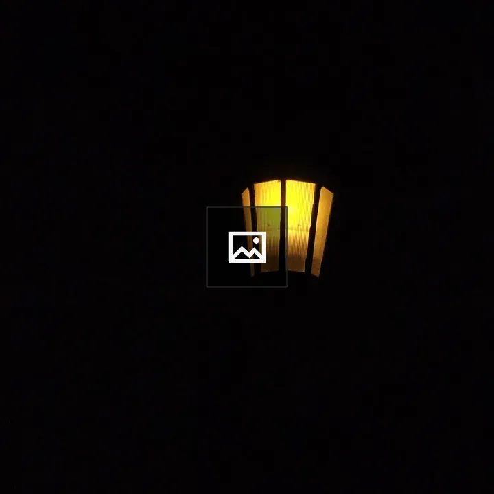 Yellow streetlamp in night darkness