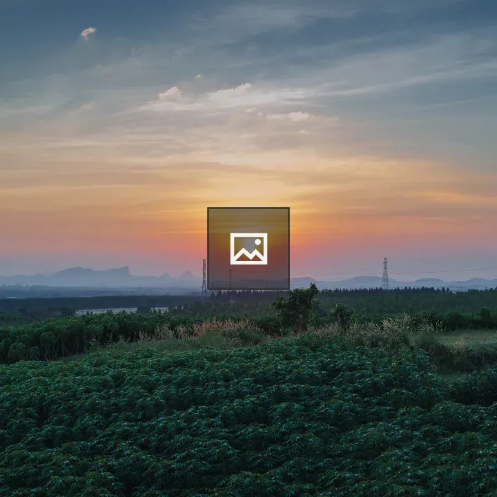 Sunset over green fields and mountains