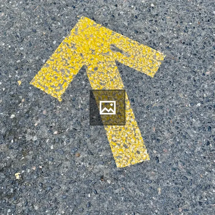 Yellow Arrow on Asphalt Road