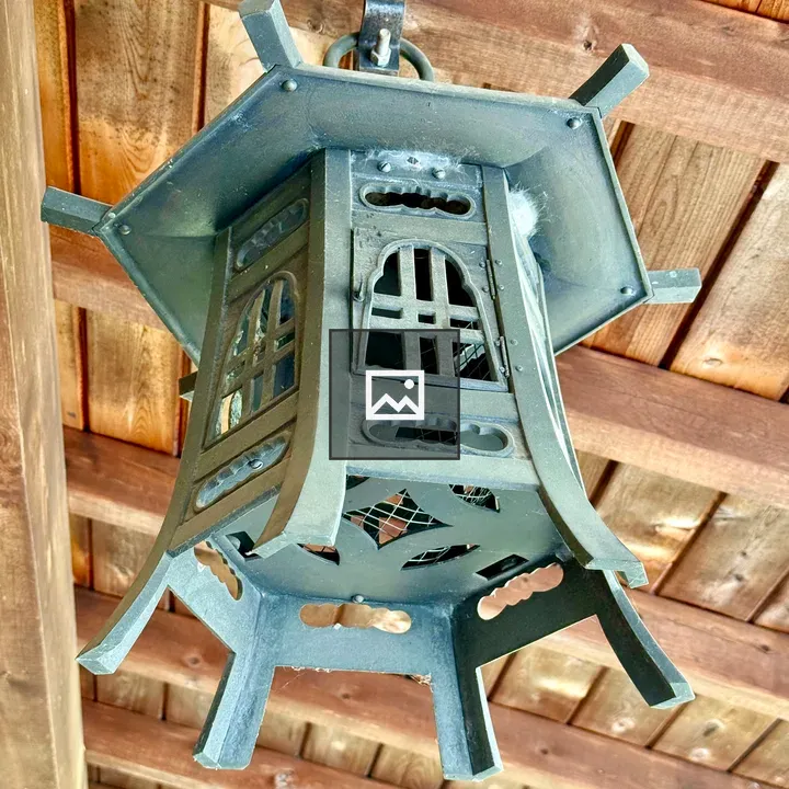 Metal lantern under wooden roof