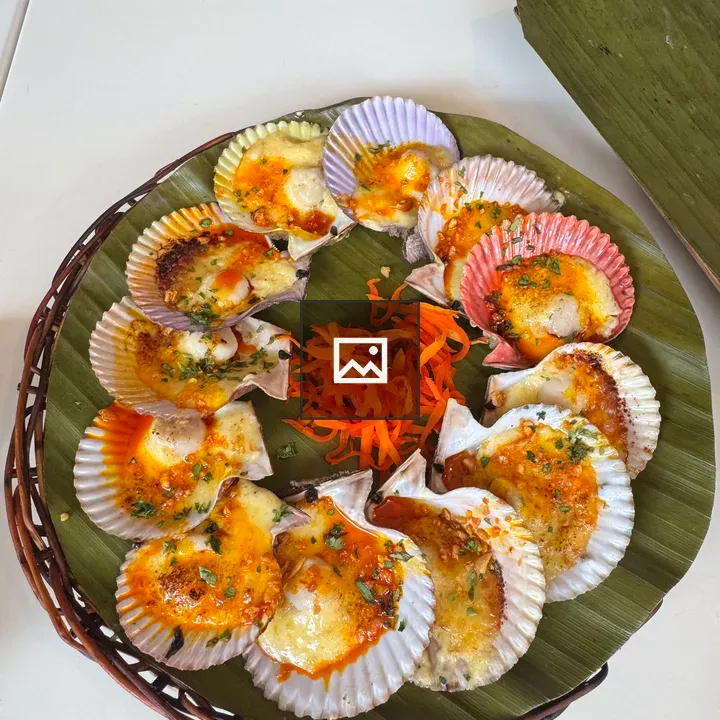 Tray of baked scallops on banana leaves