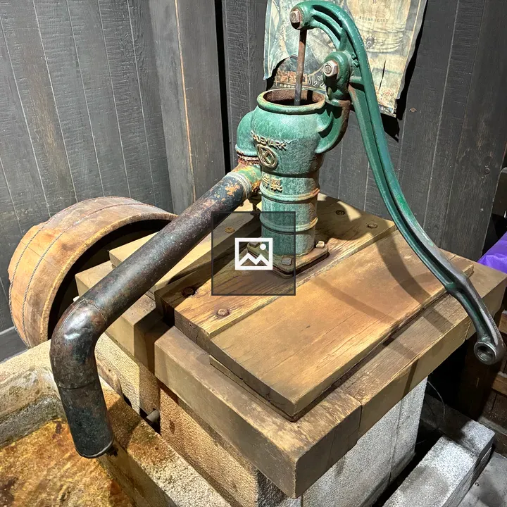 Vintage hand water pump on platform