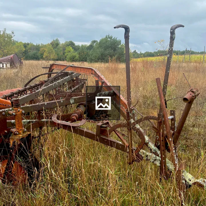 Old hay rake in field