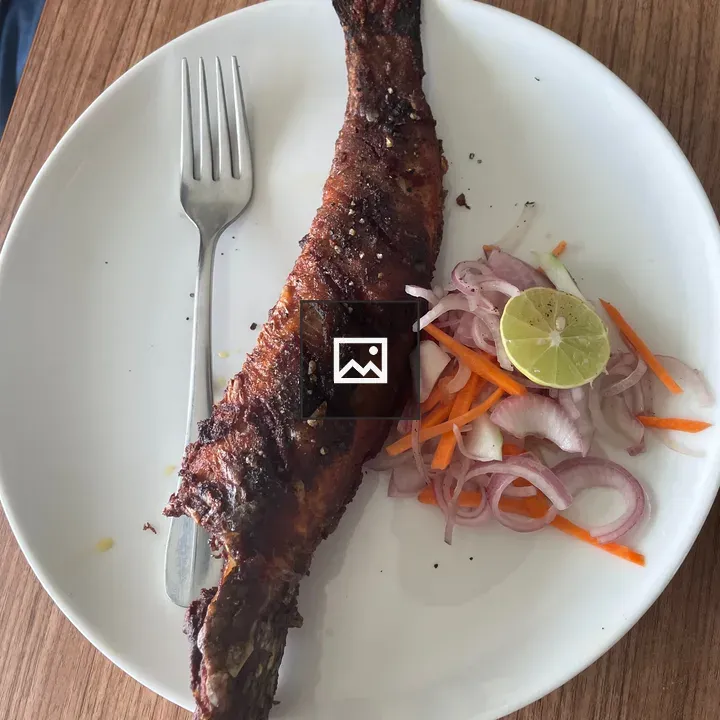 Fried fish on plate with vegetables