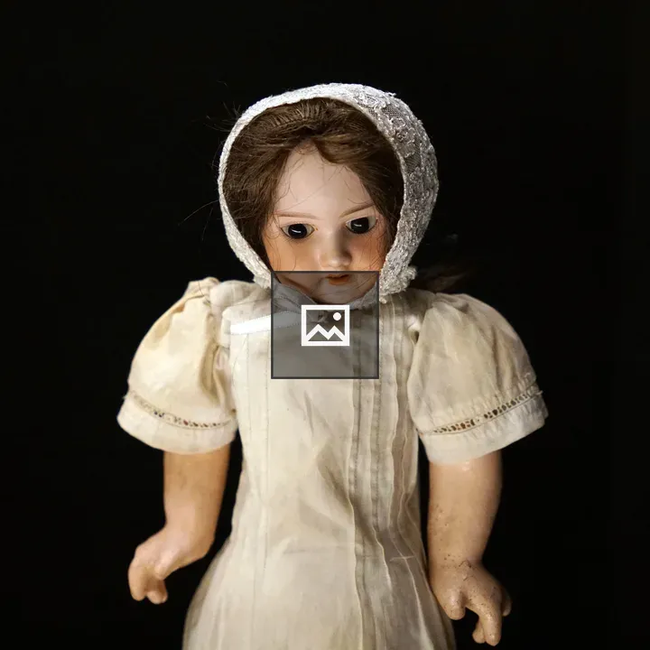 Vintage doll in white bonnet and dress