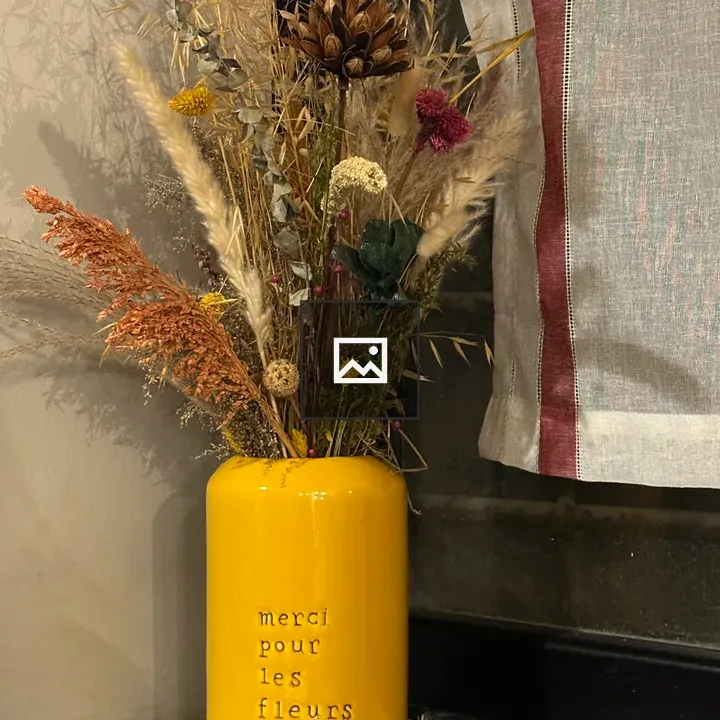 Yellow ceramic vase with dried flowers