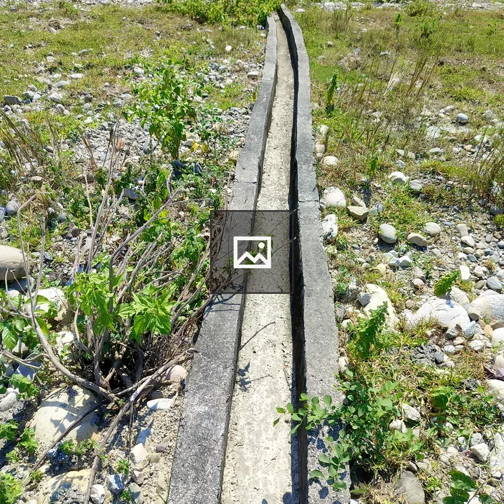Narrow ditch through grassy landscape