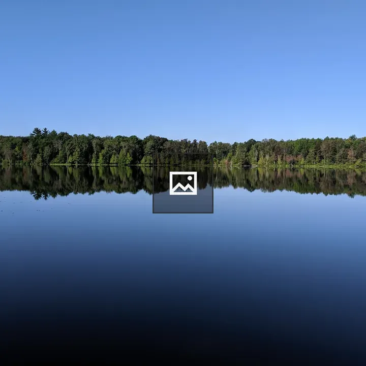 Sky and forest reflected in lake