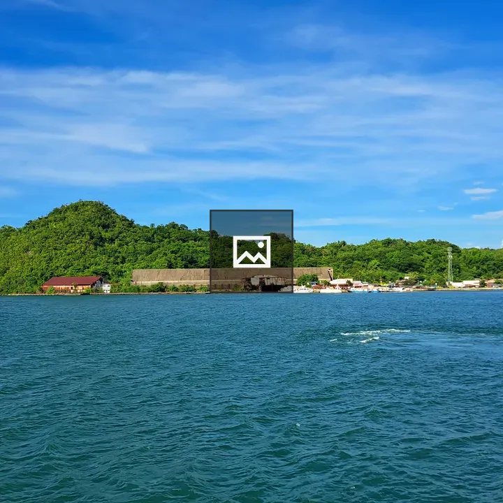 Lush Green Hill Over Blue Waters