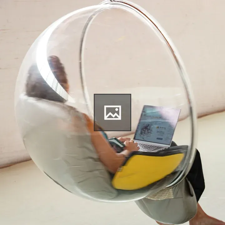 Person in bubble chair with laptop