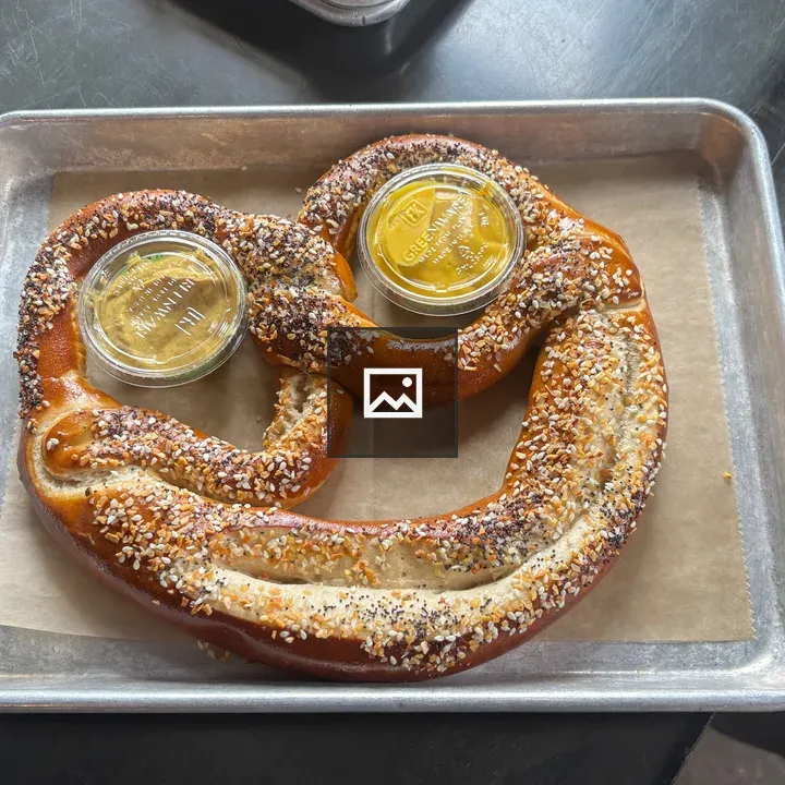 Pretzel on a steel pan with mustard