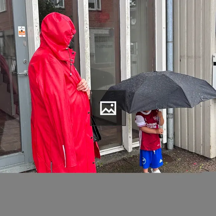 Child and adult with umbrella in rain
