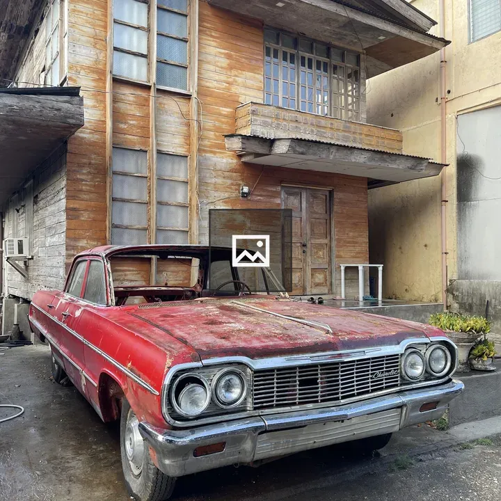 Rusty car in front of house