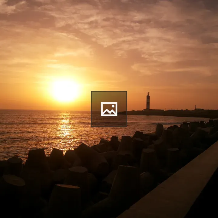 Sunset with lighthouse by tetrapods