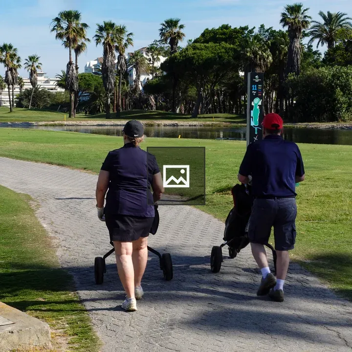Man and Woman Walking on Golf Course