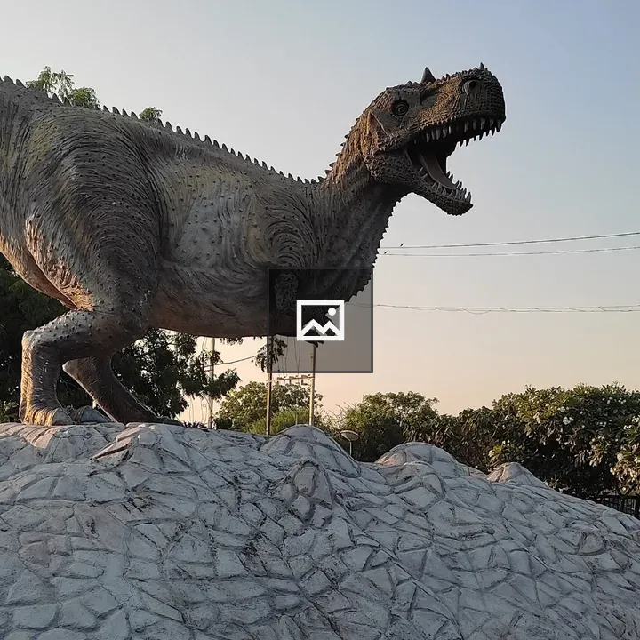 Dinosaur statue on rocky platform