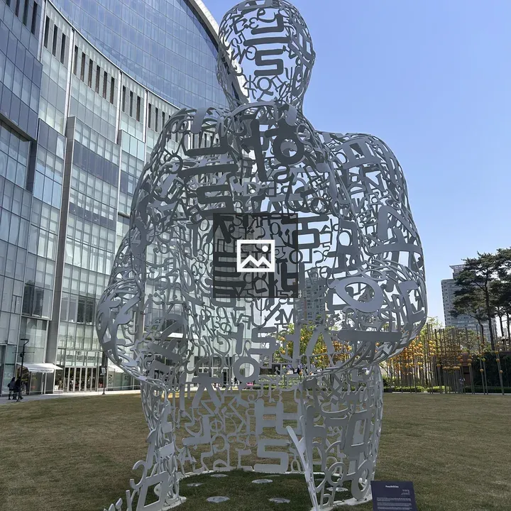 Letter sculpture in front of glass building