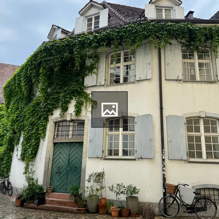 White stucco house with ivy and bicycles