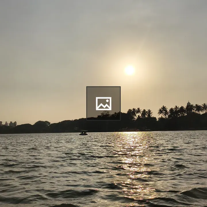 Sunset over lake with trees and boat