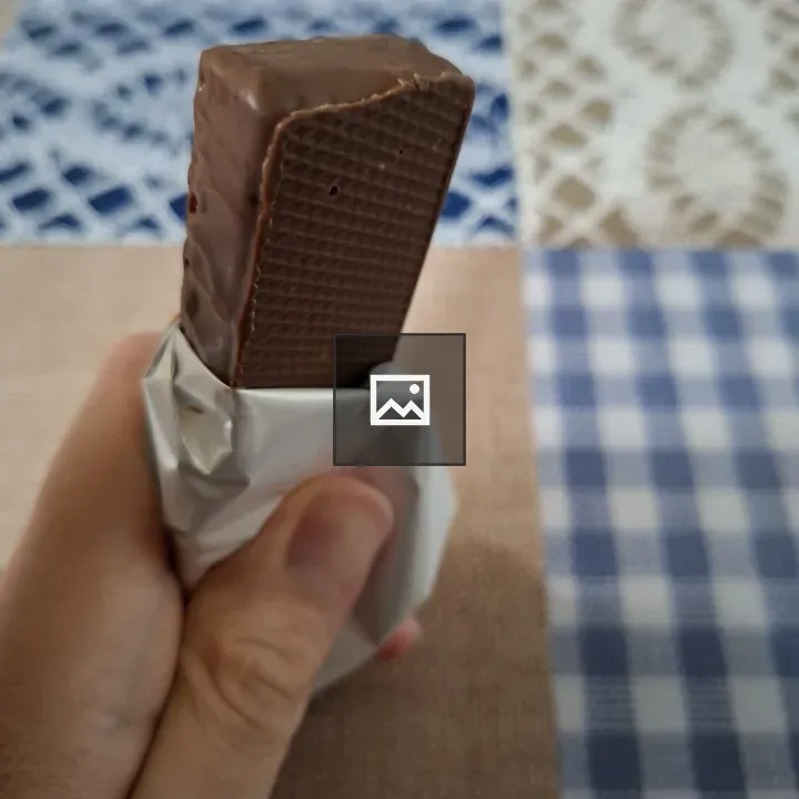 Hand grasping a chocolate bar