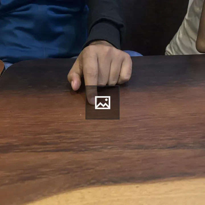 Person Pointing at Wooden Table