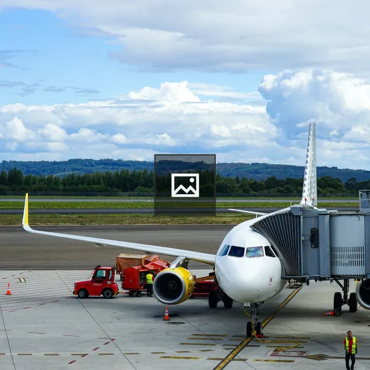 Commercial airplane on runway with ground crew