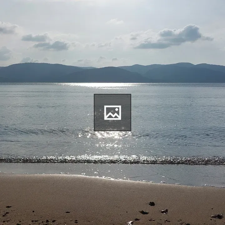 Sandy beach across from hills