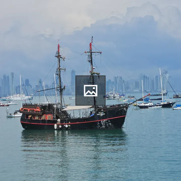 Black pirate ship in harbor