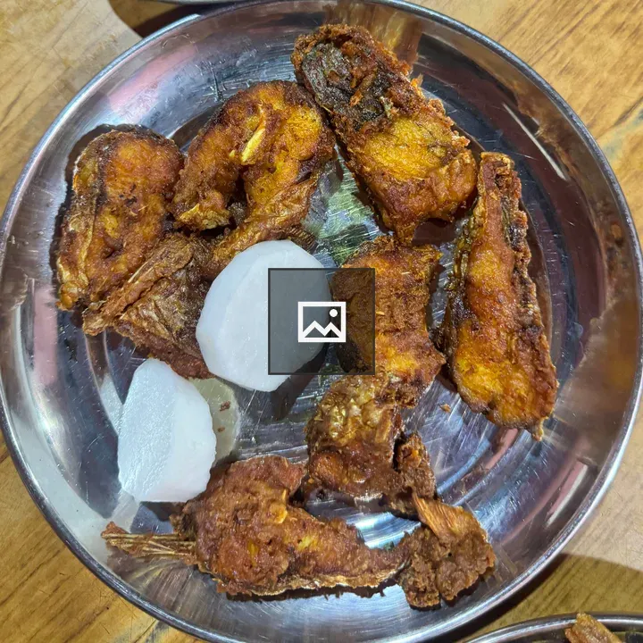 Round fried fish on metal plate