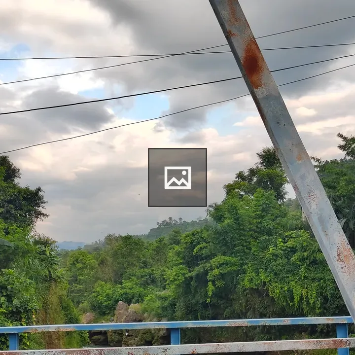 Rusted blue railing on river bridge
