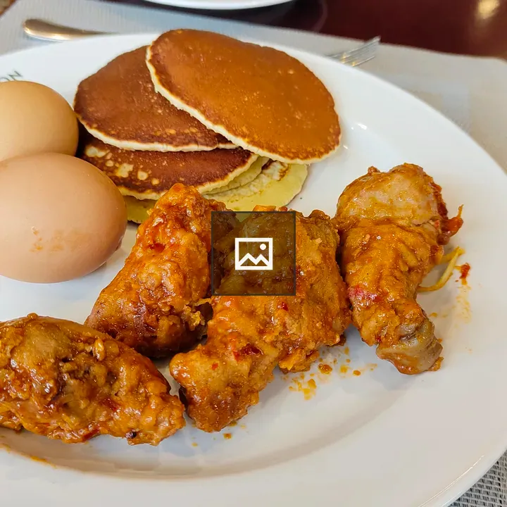 Breakfast plate of chicken, eggs, and pancakes