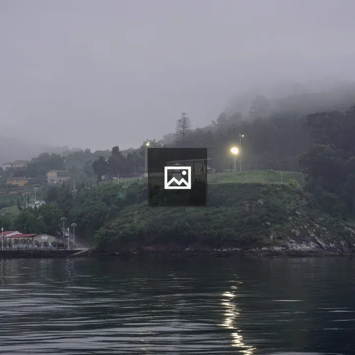Mist on grassy hill with building and lamps