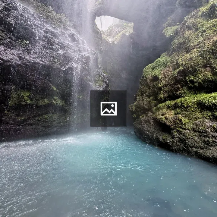 Hidden waterfall among mossy rocks