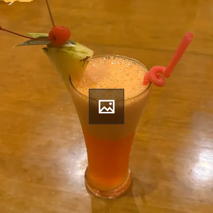 Tall orange cocktail on table