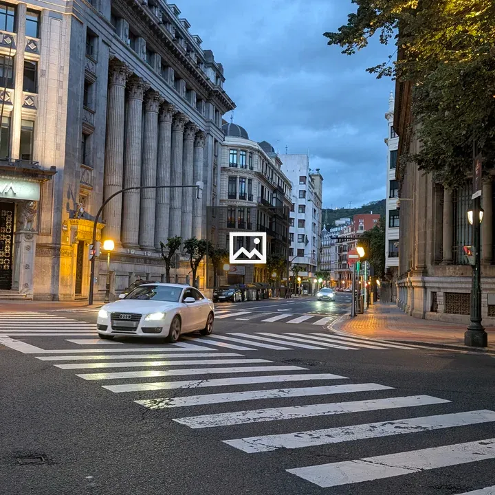 Street scene at dusk with car driving